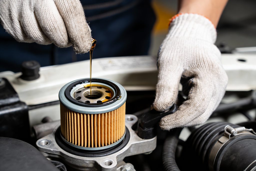Close-up,Of,A,Gloved,Hand,Pouring,Fresh,Motor,Oil,Onto